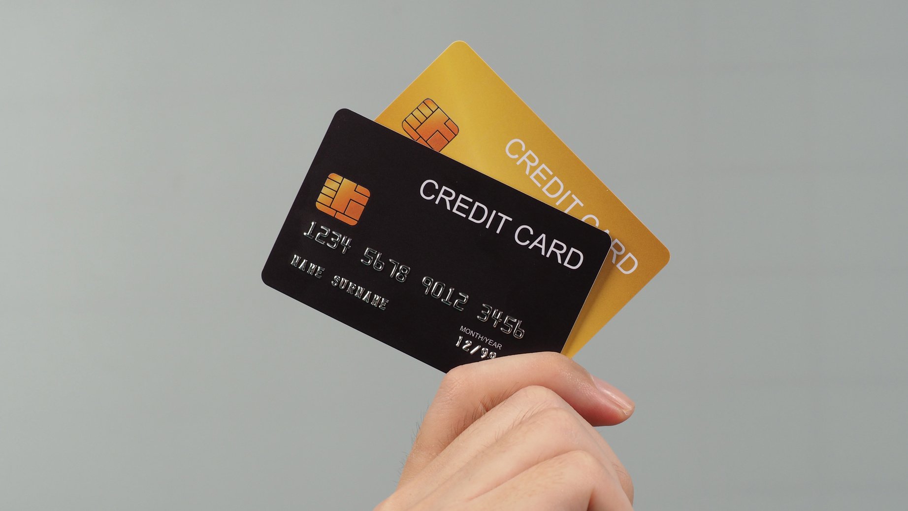 Hand Is Hold Two Credit Cards. Black and Gold Color Credit Cards